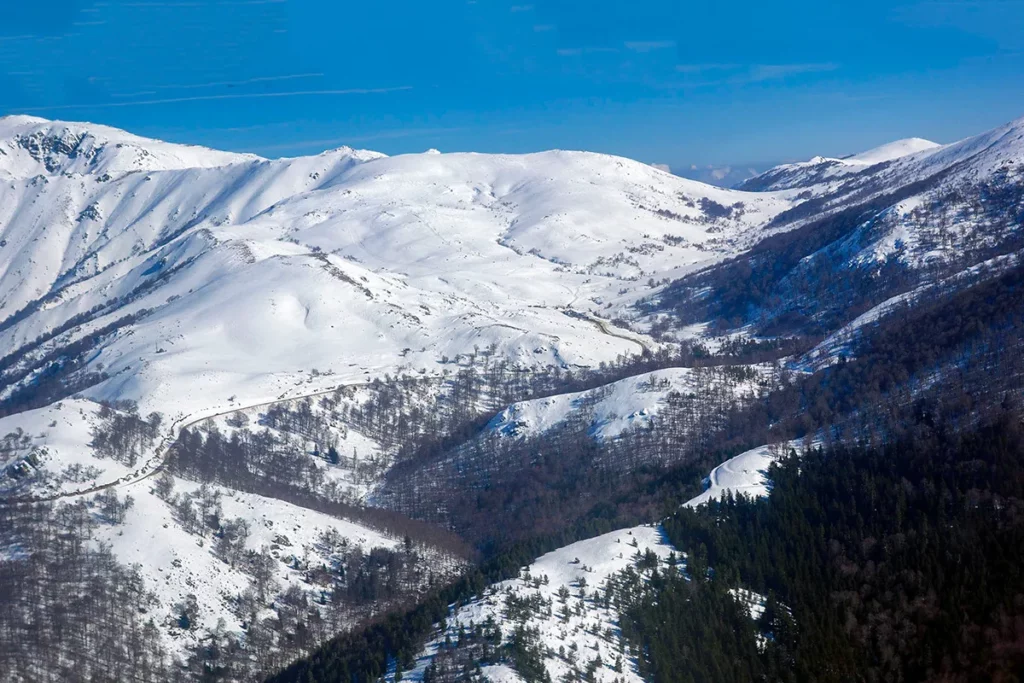 Vue aérienne des montagnes enneigées de Bastelica sous un ciel bleu